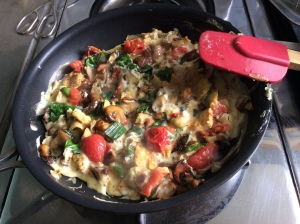 Eggs and fresh vegetables in a breakfast scramble including tomatoes, spinach, mushrooms and spring onions 